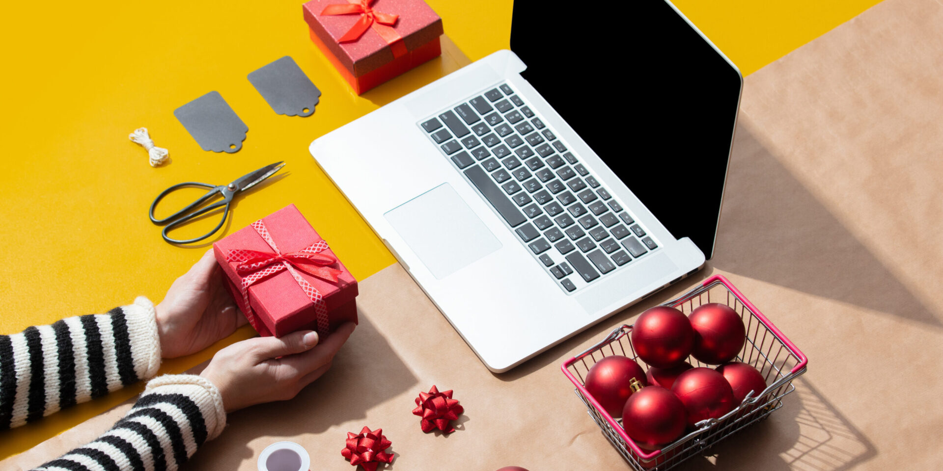 ordenador portátil rodeado de regalos y decoración navideña. Marketing Plan for Christmas.