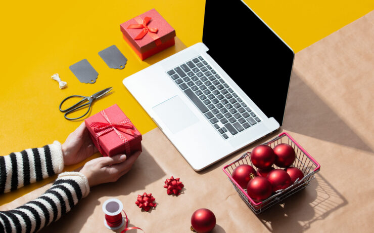 ordenador portátil rodeado de regalos y decoración navideña. Marketing Plan for Christmas.